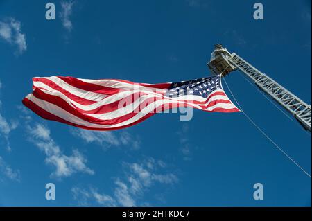 American Flag vole à gauche depuis le boom hydraulique de lutte contre les incendies. Banque D'Images