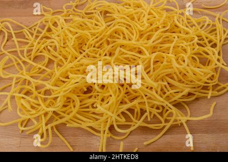 Spaghetti italiens alla chitarra sur planche à découper en bois, pâtes fraîches faites maison des Abruzzes et des Pouilles Banque D'Images