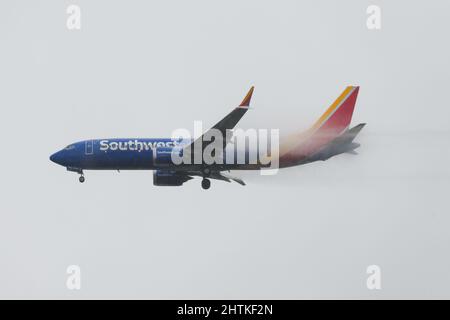 SeaTac, WA, États-Unis - 28 février 2022 ; Southwest Airlines Boeing 737 MAX-8 atterrissant sous une forte pluie avec un vortex vapeur après un vol au départ de Chicago Midway Banque D'Images