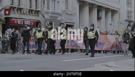 Londres, Royaume-Uni - 11 06 2021 : des policiers de la ville de Londres portant un masque facial, ont mené une foule de manifestants sur Fleet Street en COP26. Banque D'Images