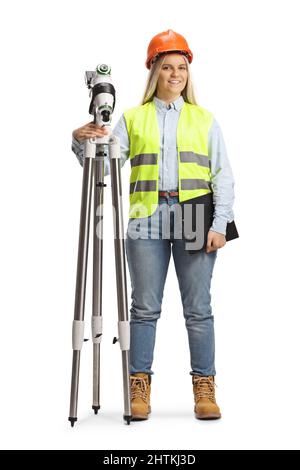 Portrait en longueur d'un géomètre géodésique femelle posé avec une station de mesure isolée sur fond blanc Banque D'Images