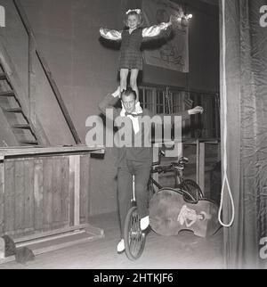 1950s performances de vélo. Un homme équilibre une fille sur ses épaules tout en pédalant sur une scène de théâtre sur un monocycle. Suède 1951 Kristoffersson réf. BE61-6 Banque D'Images