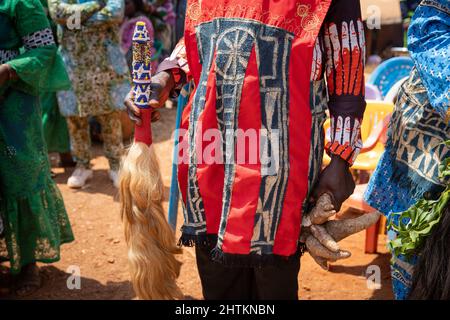 Gros plan de la robe africaine portée par un gentleman tenant une queue de cheval et un tubercule décoratifs traditionnels lors d'une célébration africaine Banque D'Images
