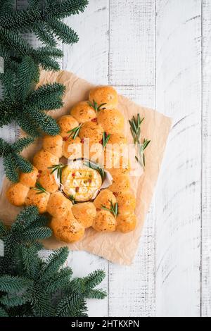 Petits pains arbre de Noël avec camembert rôti et romarin sur fond rustique en bois blanc ancien. Recettes de vacances. Menu de Noël. Noël Banque D'Images