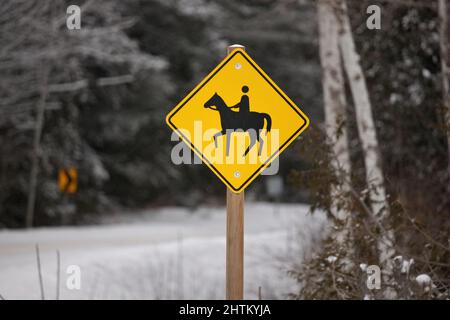 Jaune attention Horse Riding Sign dans un cadre rural en hiver Banque D'Images