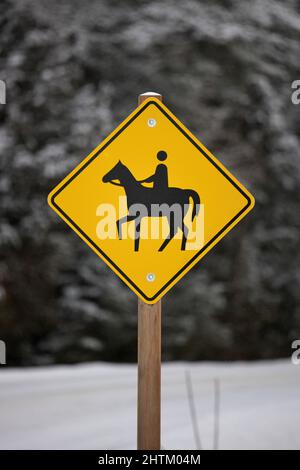 Jaune attention Horse Riding Sign dans un cadre rural en hiver Banque D'Images
