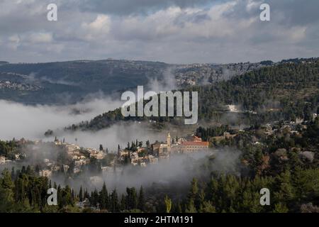 Brouillard matinal dans les vallées autour de Jérusalem, Israël. Quartier Ein karem au premier plan. Banque D'Images