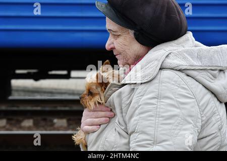 Kramatorsk, Ukraine. 27th févr. 2022. Une femme avec son chien marche vers le train d'évacuation à Kramatorsk. Le président russe Vladimir Poutine a ordonné l'intervention militaire le 24 février, quelques jours après avoir reconnu deux enclaves séparatistes dans l'est de l'Ukraine. Il a affirmé que Moscou n'avait aucun plan pour occuper le pays voisin mais voulait "démilitariser" et "dénaziser" l'Ukraine. Le président ukrainien Volodymyr Zelenskyy a accusé la Russie d'essayer d'installer un gouvernement fantoche et a déclaré que les Ukrainiens défendront leur pays contre l'agression russe. Crédit : SOPA Images Limited/Alamy Live News Banque D'Images