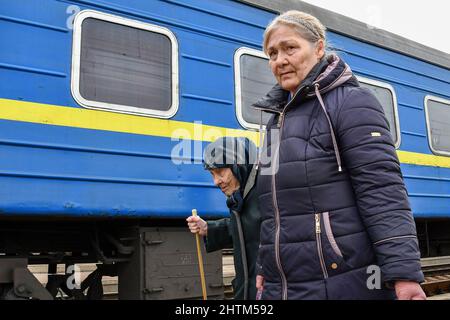 Kramatorsk, Donetsk, Ukraine. 27th févr. 2022. Deux femmes âgées sont vues marcher pour entrer dans le train pour l'évacuation de Kramatorsk. Le président russe Vladimir Poutine a ordonné l'intervention militaire le 24 février, quelques jours après avoir reconnu deux enclaves séparatistes dans l'est de l'Ukraine. Il a affirmé que Moscou n'avait aucun plan pour occuper le pays voisin mais voulait 'démilitariser' et 'dénaziser' l'Ukraine. Le président ukrainien Volodymyr Zelenskyy a accusé la Russie d'essayer d'installer un gouvernement fantoche et a déclaré que les Ukrainiens défendront leur pays contre l'agression russe. (Crédit Banque D'Images