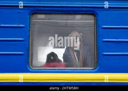 Kramatorsk, Donetsk, Ukraine. 27th févr. 2022. Une fille regarde par une fenêtre de chariot du train d'évacuation de Kramatorsk. Le président russe Vladimir Poutine a ordonné l'intervention militaire le 24 février, quelques jours après avoir reconnu deux enclaves séparatistes dans l'est de l'Ukraine. Il a affirmé que Moscou n'avait aucun plan pour occuper le pays voisin mais voulait 'démilitariser' et 'dénaziser' l'Ukraine. Le président ukrainien Volodymyr Zelenskyy a accusé la Russie d'essayer d'installer un gouvernement fantoche et a déclaré que les Ukrainiens défendront leur pays contre l'agression russe. (Image de crédit : © A Banque D'Images