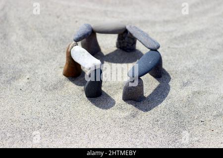 Galets équilibrés sur la côte sablonneuse. Des pierres sont empilées sur la plage. Petite stonehenge Banque D'Images