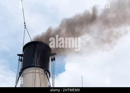 Le feu de charbon noir fume des fours de l'entonnoir du remorqueur à vapeur historique de 1902 Waratah tout en naviguant dans le port de Sydney en Australie Banque D'Images