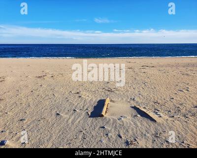 Plage de sable et un plan d'eau lors d'une journée ensoleillée avec des nuages légers en arrière-plan Banque D'Images