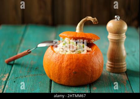 Citrouille entière rôtie avec riz et viande avec moulin à poivre, mise au point horizontale sélective Banque D'Images