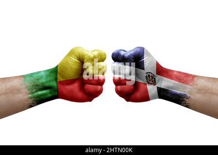 Deux mains poinçonner l'une à l'autre sur fond blanc. Drapeaux de pays peints poings, conflit concept de crise entre le bénin et la république dominicaine Banque D'Images