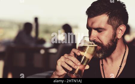 Joyeux sourire avec de la bière. Homme buvant de la bière. Émotif drôle de barbu hipster contient de la bière artisanale en bouteille. Banque D'Images