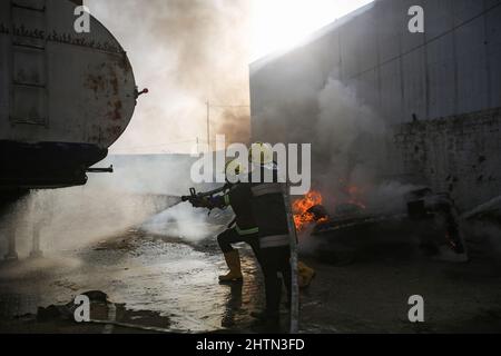 Gaza, Palestine. 01st mars 2022. Des membres de la Défense civile palestinienne loyaux au Hamas ont mis le feu lors d'un grand exercice dans la ville de Gaza, lors de la Journée mondiale de la Défense civile. Chaque année, le 1 mars, les gens du monde entier célèbrent la Journée mondiale de la Défense. Cette journée a été déclarée jour férié mondial par l'Organisation internationale de défense civile (OCIM) en 1990 et honore l'importance de la défense civile et du personnel qui a sacrifié leur vie pour elle. Crédit : SOPA Images Limited/Alamy Live News Banque D'Images