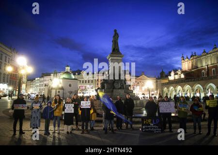 (NOTE DE LA RÉDACTION: L'image contient des blasphèmes)les manifestants tiennent des drapeaux et des pancartes lors d'une manifestation contre la guerre en Ukraine sur la place principale de Cracovie. Banque D'Images