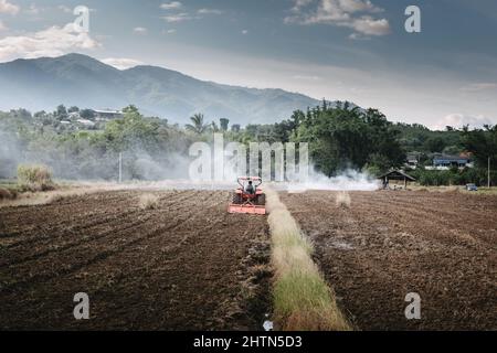 Un travailleur agricole a conduit un tracteur pour le travail du sol dans les champs agricoles. Travaux agricoles préparation du labour sur tracteur pour la plantation de cultures. Rura Banque D'Images