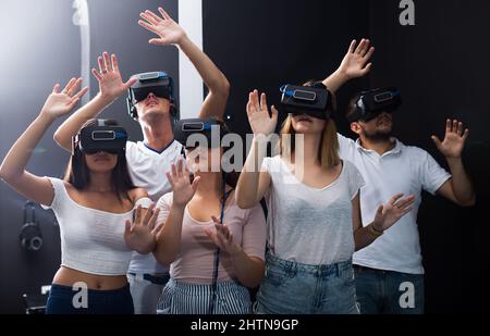 les femmes et les hommes immergés dans la réalité virtuelle avec 3d lunettes Banque D'Images