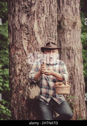 Cueillette de champignons. Grand-père heureux avec des champignons dans le champignon de chasse de bucket. Banque D'Images