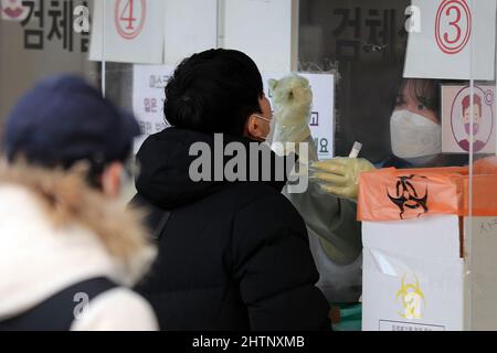 (220302) -- SÉOUL, le 2 mars 2022 (Xinhua) -- Un professionnel de la santé prélève un échantillon d'écouvillon d'un homme pour le test COVID-19 sur un site de test improvisé à Séoul, en Corée du Sud, le 2 mars 2022. La Corée du Sud a signalé un record quotidien de 219 241 nouveaux cas de COVID-19 à minuit mardi par rapport à 24 heures auparavant, portant le nombre total d'infections à 3 492 686, ont déclaré les autorités sanitaires mercredi. (NEWSIS/document via Xinhua) Banque D'Images