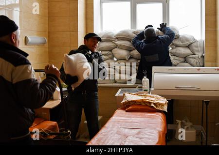 Kramatorsk, Ukraine, 1/3/2022, les travailleurs placent des sacs de sable près de la fenêtre pour la protection dans l'hôpital de la ville de Kramatorsk. Le président russe Vladimir Poutine a ordonné l'intervention militaire le 24 février, quelques jours après avoir reconnu deux enclaves séparatistes dans l'est de l'Ukraine. Il a affirmé que Moscou n'avait aucun plan pour occuper le pays voisin mais voulait "démilitariser" et "dénaziser" l'Ukraine. Le président ukrainien Volodymyr Zelenskyy a accusé la Russie d'essayer d'installer un gouvernement fantoche et a déclaré que les Ukrainiens défendront leur pays contre l'agression russe. Banque D'Images