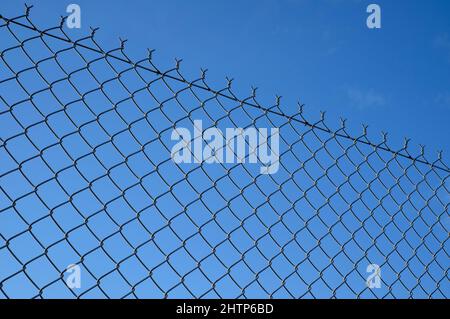 clôture métallique à maillons de chaîne sur fond bleu ciel Banque D'Images