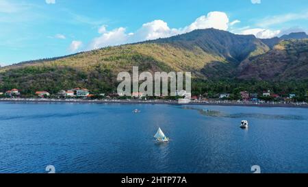 Vue aérienne de la plage d'Amed à Bali, Indonésie. Bateaux de pêche traditionnelles appelées jukung sur la plage de sable noir et le Mont Agung volcan de la Banque D'Images