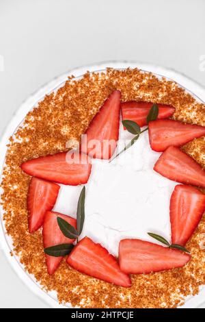 Gâteau au miel maison complet garni de tranches de fraises Banque D'Images