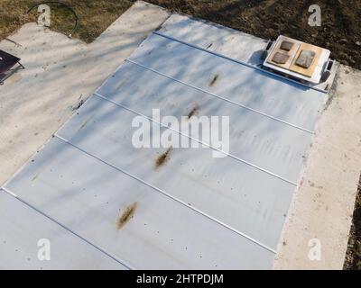 Un drone survolait une piscine couverte avec une bâche encore en construction dans un jardin Banque D'Images