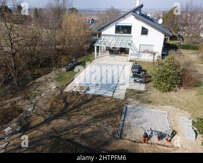 Un drone survolait une piscine couverte avec une bâche encore en construction dans un jardin Banque D'Images
