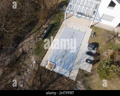 Un drone survolait une piscine couverte avec une bâche encore en construction dans un jardin Banque D'Images