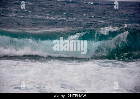 Une grande vague chevauche la côte de l'île croate de Losinj. Une vague qui s'écrase sur la côte rocheuse. Banque D'Images