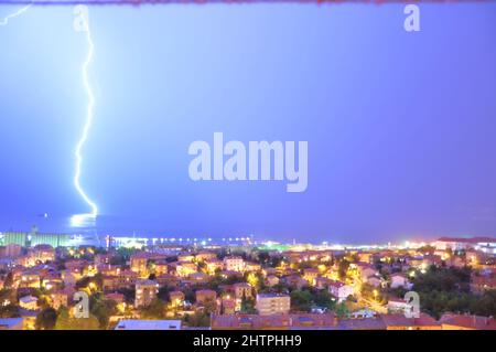 Tempête de nig avec un éclair frappant la mer Adriatique dans la baie de Rijeka, Croatie. Des éclairs spectaculaires sur une baie de mer calme. Banque D'Images