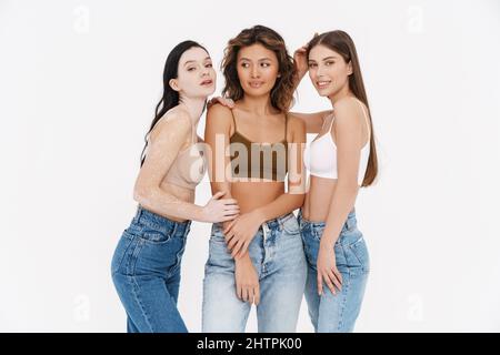 Trois jeunes femmes portant un soutien-gorge souriant ensemble à la caméra isolée sur fond blanc Banque D'Images