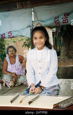 Belle fille thaïlandaise jouant Khim instrument de musique traditionnelle près de grand-mère Banque D'Images