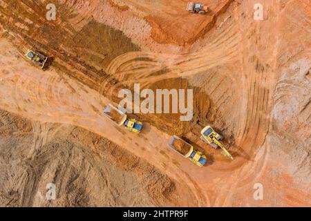 Vue aérienne d'un grand chantier de construction avec plusieurs excavateurs sur chenilles en déplaçant la terre sur le camion à benne basculante Banque D'Images