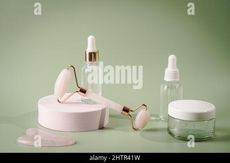 Rouleaux de visage de Jade et pierres de Gua sha pour la thérapie de massage de beauté du visage, articles pour le soin à domicile avec les outils anti-âge de soin de peau et le sérum de visage sur gre Banque D'Images