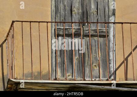 Ancienne maison néoclassique rouillée sur mesure balcon en fer forgé balustrade contre un mur en stuc ocre à Nafplio, Grèce. Banque D'Images