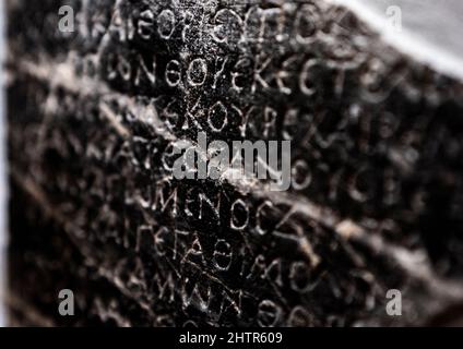 Inscriptions grecques antiques sculptées dans une roche noire volcanique, Musée archéologique d'Héraklion, île de Crète, Grèce Banque D'Images