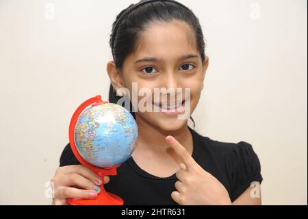 Mumbai Maharashtra Inde Asie août 24 2021 petite fille indienne mignon tenant le World Globe sur ses mains montrant le concept d'éducation de l'Inde. Banque D'Images