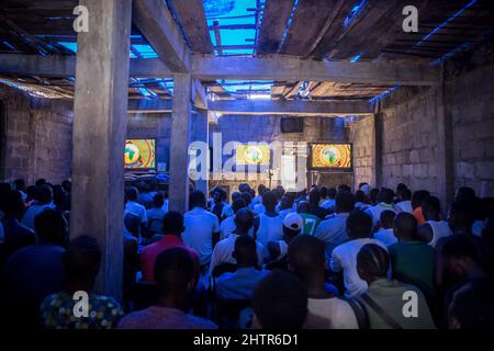 Freetown, Sierra Leone. 12th janvier 2022. Les habitants de la région regardent un match de football dans un « cinéma » à Freetown.Sierra Leone s'est qualifié pour la coupe d'Afrique des Nations en 2022 pour la première fois en 26 ans, donnant l'espoir à de nombreux joueurs de football locaux d'obtenir plus d'opportunités internationales à l'avenir. Crédit : SOPA Images Limited/Alamy Live News Banque D'Images