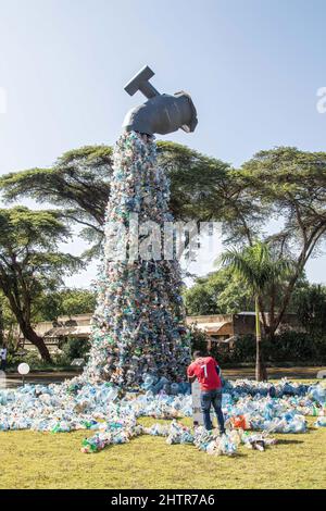 Le 27 février 2022, Nairobi, Kenya : un homme vu à côté d'une installation de déchets d'art en plastique par un activiste et artiste canadien, Benjamin von Wong exposé devant le siège du Programme des Nations Unies pour l'environnement à Nairobi lors de la conférence de l'UNEA..Assemblée des Nations Unies pour l'environnement le worldÃ­s principal organe décisionnel en matière d'environnement a été lancé hier par des remarques liminaires de son président Espen Barth Eide, qui a réitéré pour une action multilatérale visant à mettre fin à la pollution plastique. Le Rwanda et le Pérou ont proposé un projet de résolution juridiquement contraignant avec une approche plastique du cycle de vie complet. (Crédit IMA Banque D'Images