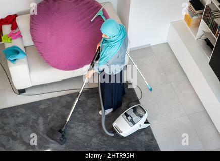 Bonne femme musulmane nettoyage moderne de la maison salon. Photo de haute qualité Banque D'Images