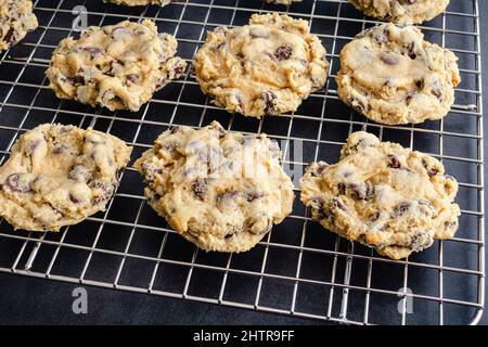 Biscuits aux pépites de chocolat sur un rack de refroidissement en fil de fer : biscuits aux pépites de chocolat frais et cuits sur un rack en métal Banque D'Images