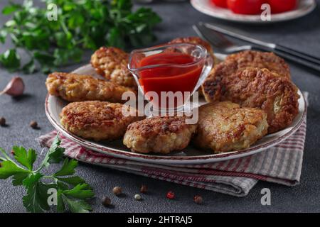 Côtelettes de filet de dinde et de flocons d'avoine, frites dans une poêle, servies avec une sauce tomate, gros plan Banque D'Images