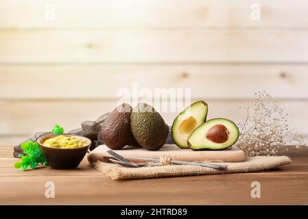 Ensemble d'avocats sur un fond en bois avec un bol de guacamole trempette Banque D'Images