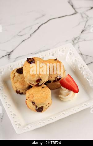 Scone anglais avec frites au chocolat, servi avec fraise, sur une table en marbre Banque D'Images