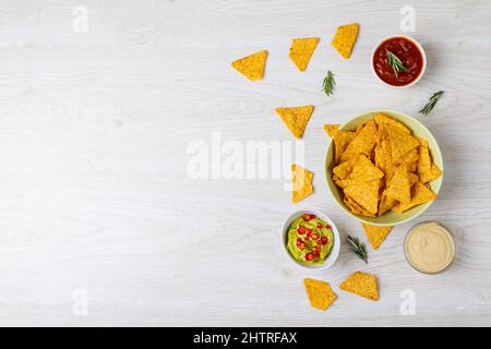 Vue en hauteur de diverses sauces à trempette servies avec des frites nacho dans un bol sur une table avec espace vide Banque D'Images